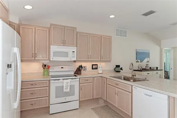 a kitchen with white cabinets and white appliances