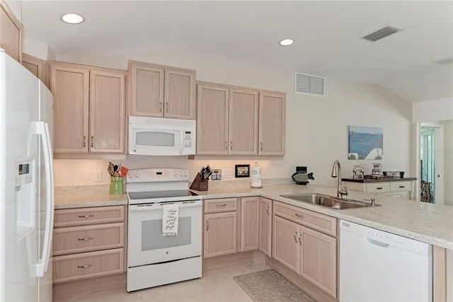 a kitchen with white cabinets and white appliances