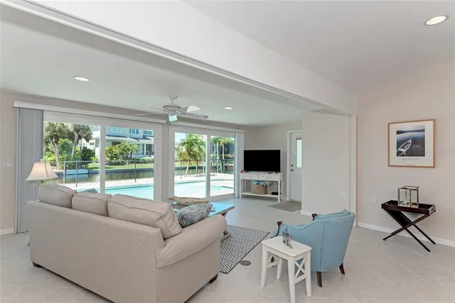 a living room with furniture a flat screen tv and a large window