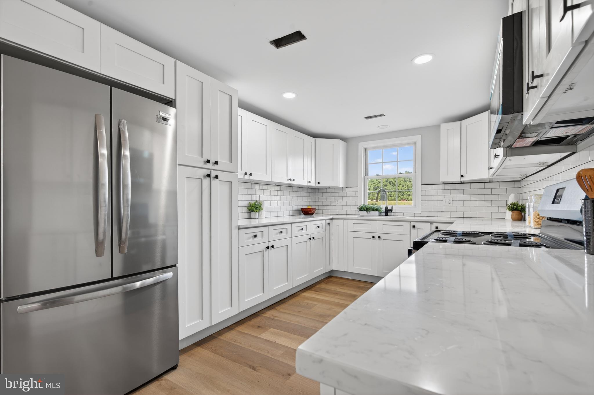 22045 Carters Gate Road Ruther Glen, VA 22546 - Photo 8 of 27 a kitchen with stainless steel appliances a refrigerator sink and white cabinets