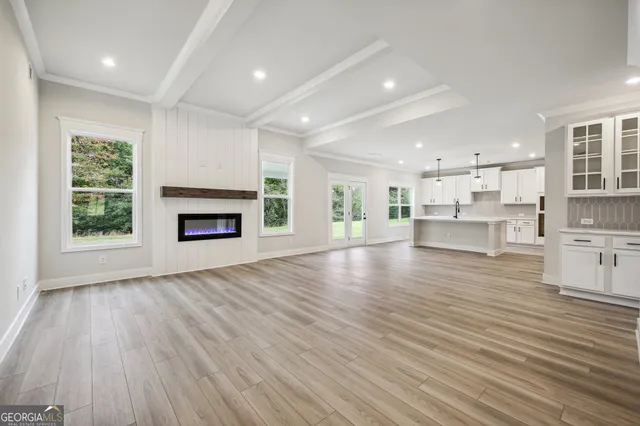 an empty room with wooden floor fireplace and windows
