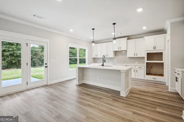 a view of a hallway with wooden floor and entryway
