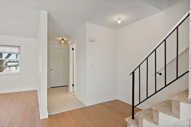 a view of a hallway with wooden floor and stairs