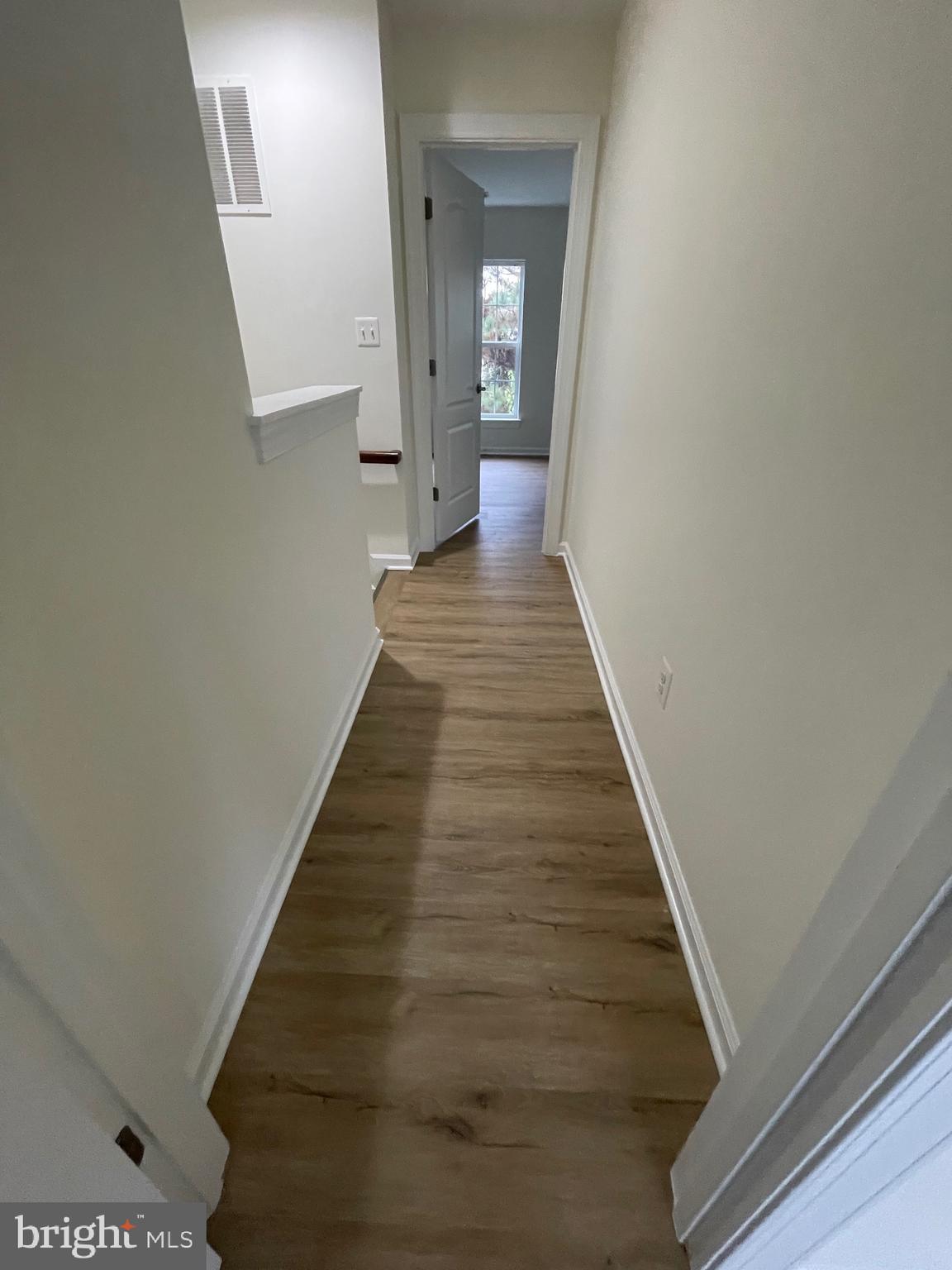 7454 Riding Meadow Way Manassas, VA 20111 - Photo 12 of 21 a view of a hallway with wooden floor and staircase