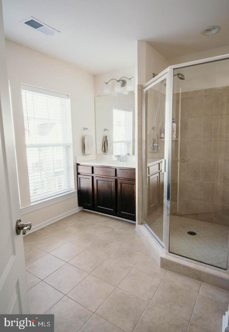 7454 Riding Meadow Way Manassas, VA 20111 - Photo 9 of 21 a spacious bathroom with a glass shower door and a window