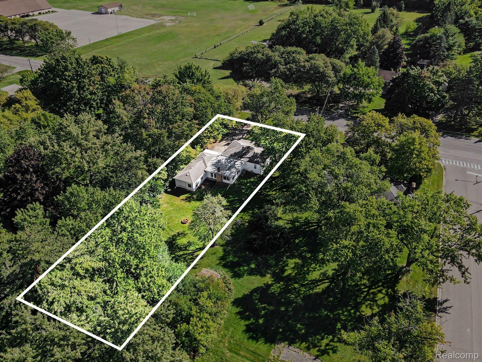 207 Elms Road Flushing, MI 48433 - Photo 26 of 30 Expansive lot featuring mature trees, a manicured lawn, and a light-colored shingle roof