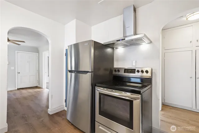 a metallic refrigerator freezer and a stove sitting inside of a kitchen