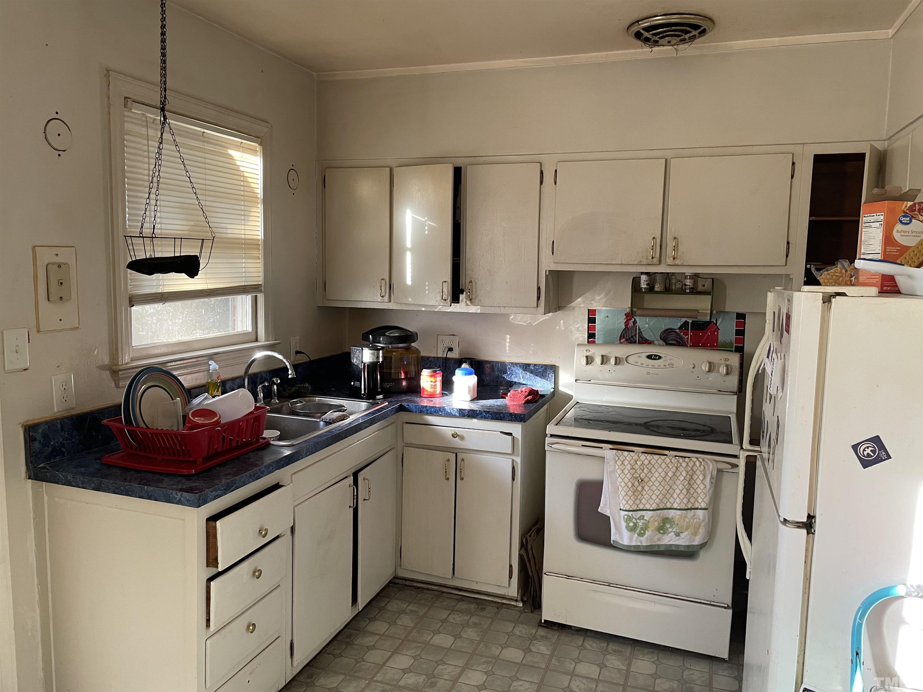 1518 Ashburton Road Raleigh, NC 27606 - Photo 4 of 10 a kitchen with a stove and white cabinets