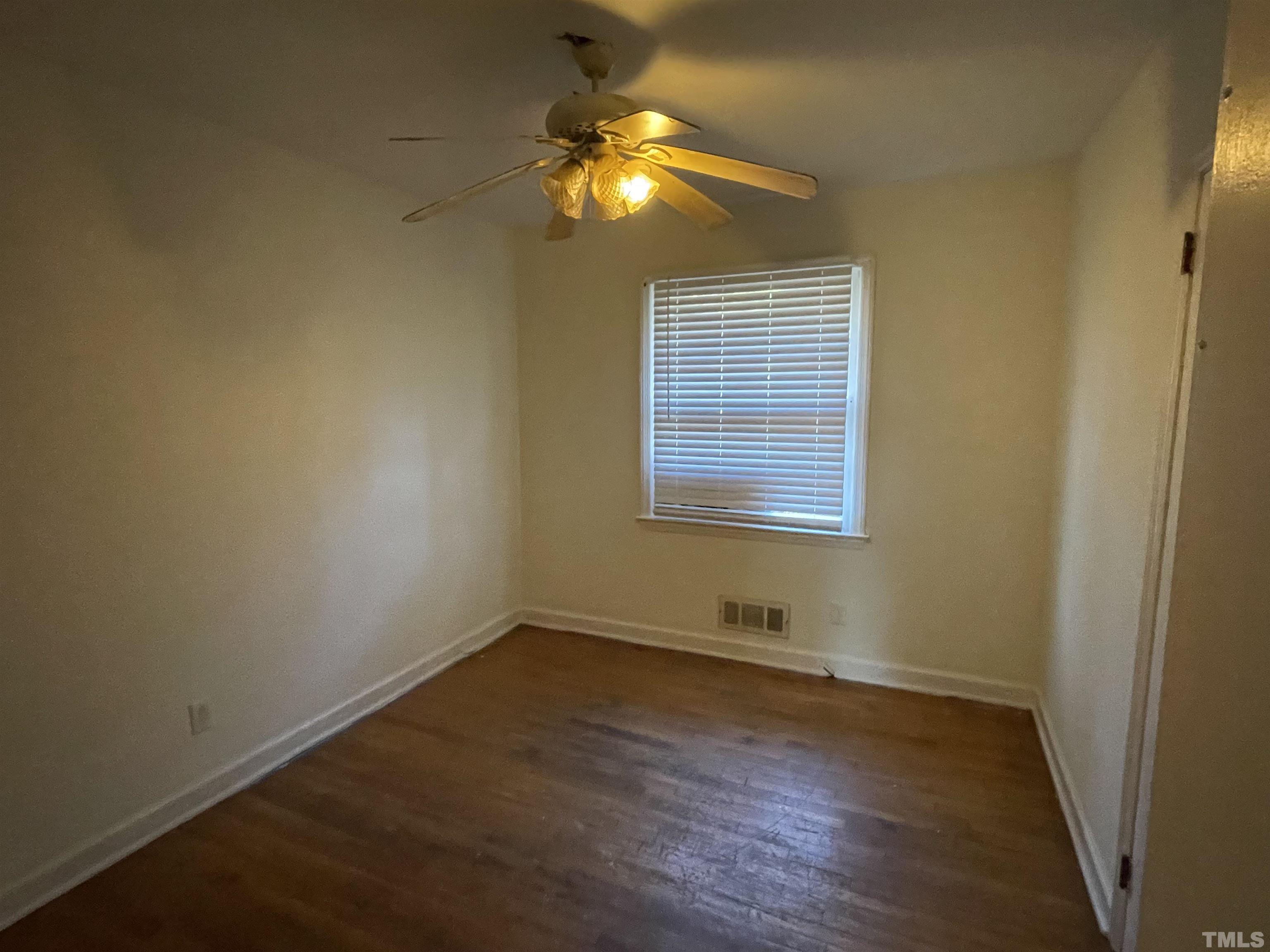 1518 Ashburton Road Raleigh, NC 27606 - Photo 5 of 10 an empty room with wooden floor and windows