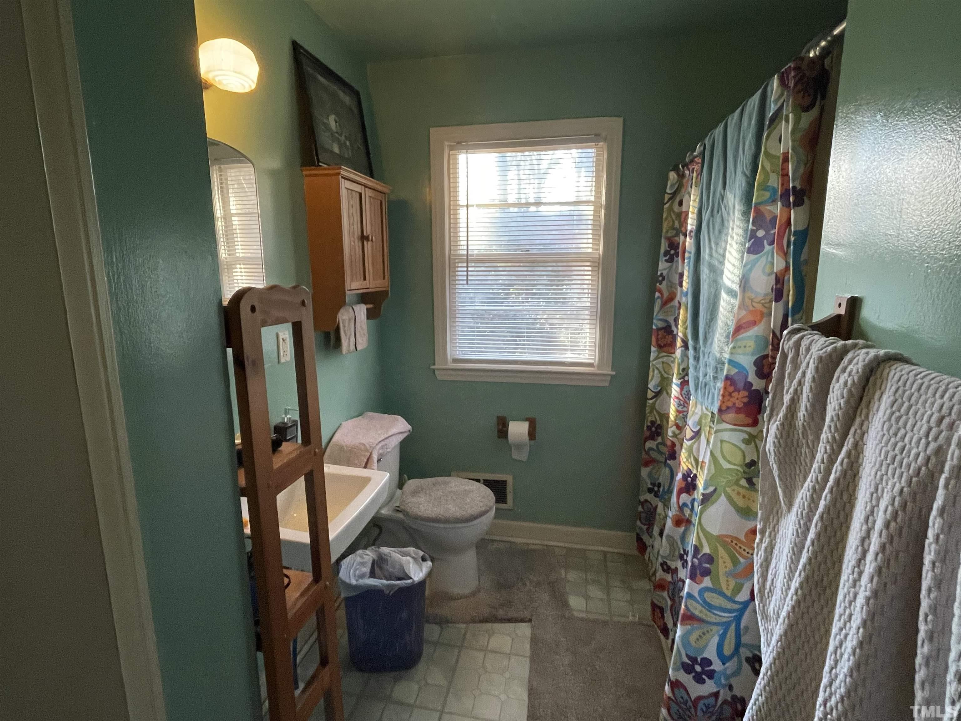 1518 Ashburton Road Raleigh, NC 27606 - Photo 6 of 10 a bathroom with a sink toilet and mirror