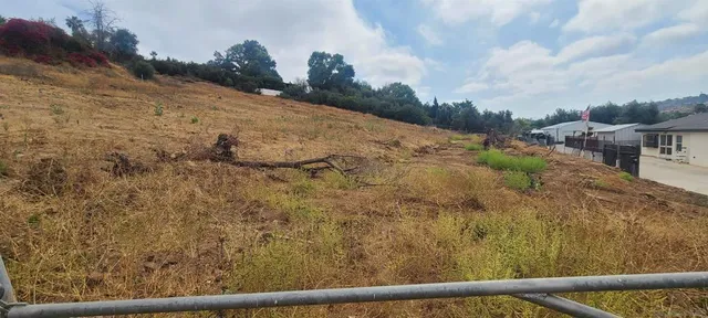 a view of a yard with wooden fence