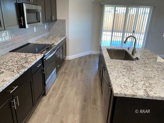 1629 Mayo Street Ridgecrest, CA 93555 - Photo 10 of 25 a kitchen with granite countertop a sink a counter top space appliances and cabinets