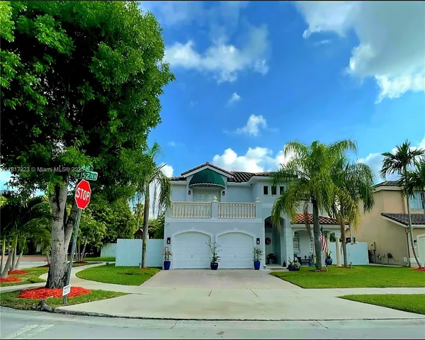 a dining hall with stainless steel appliances kitchen island granite countertop a refrigerator and a sink