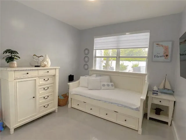 a bed sitting in a bedroom next to a window