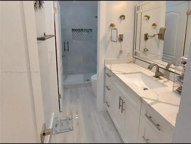 a bedroom with a bed and a flat tv screen on dresser