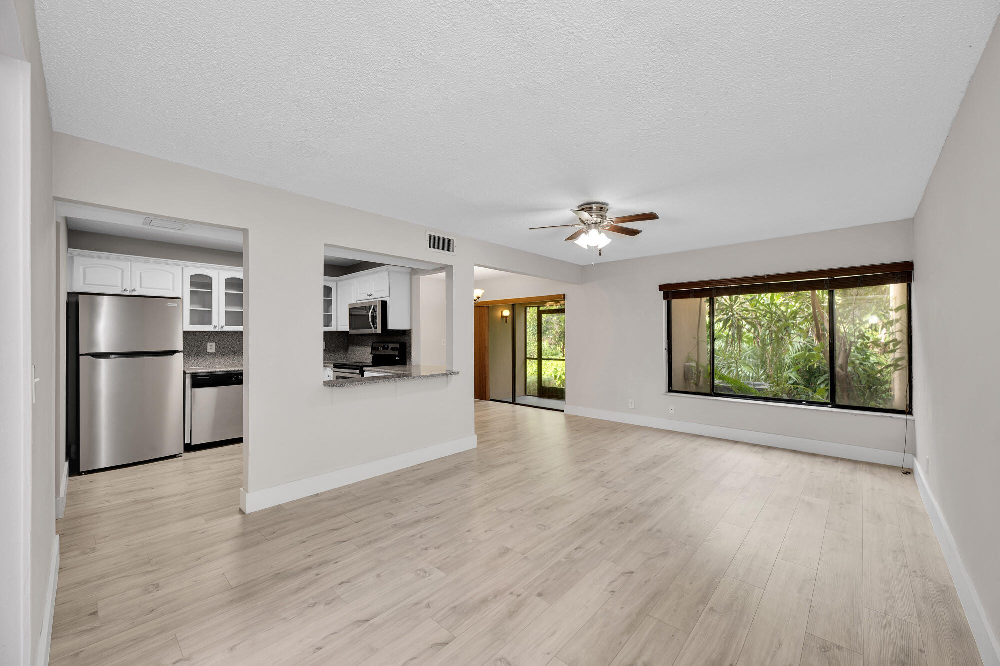 1169 Northwest 13th Street, Unit 1 Boca Raton, FL 33486 - Photo 2 of 20 a view of an empty room with a window and wooden floor