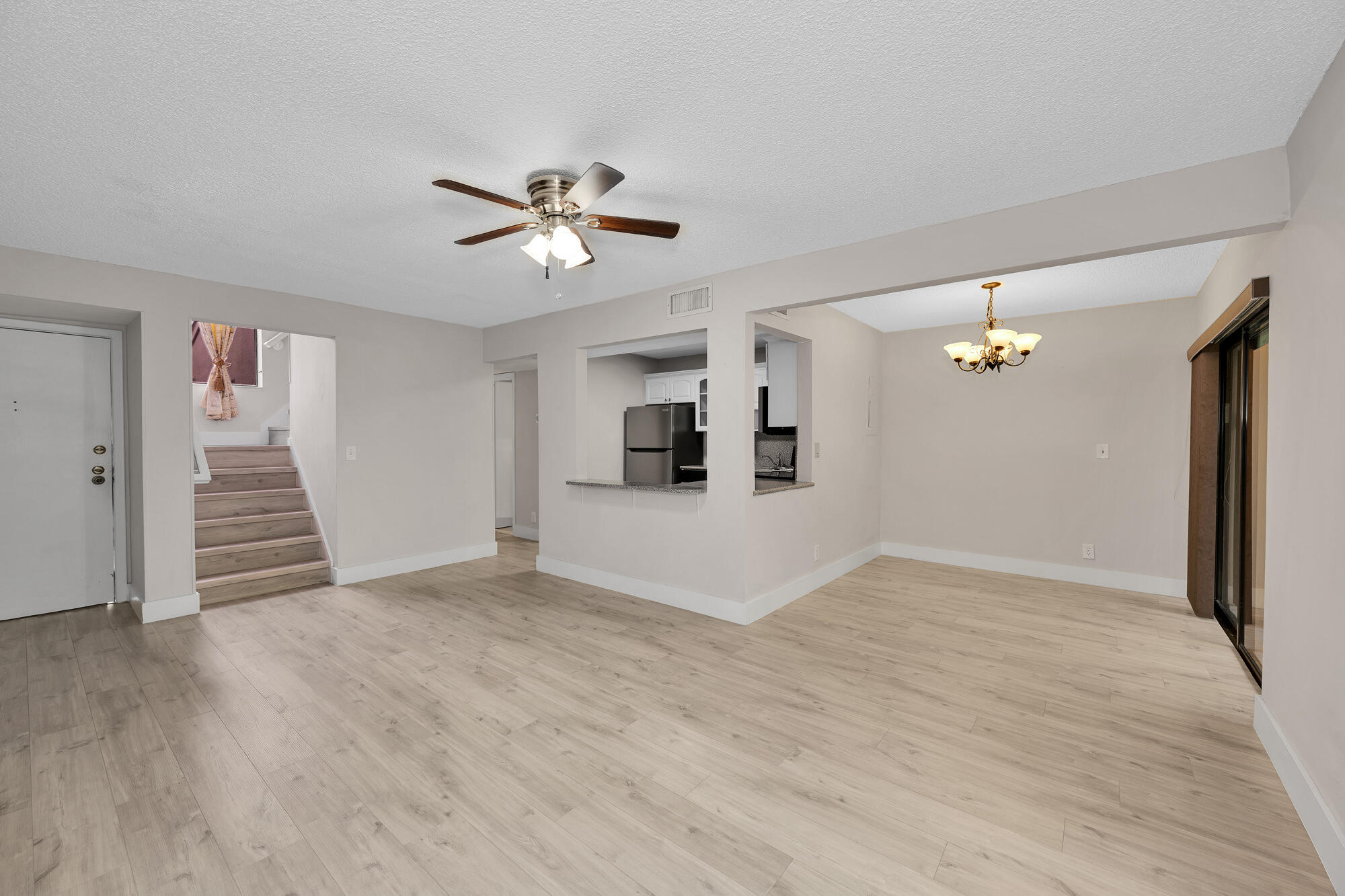 1169 Northwest 13th Street, Unit 1 Boca Raton, FL 33486 - Photo 3 of 20 a view of empty room with wooden floor and ceiling fan