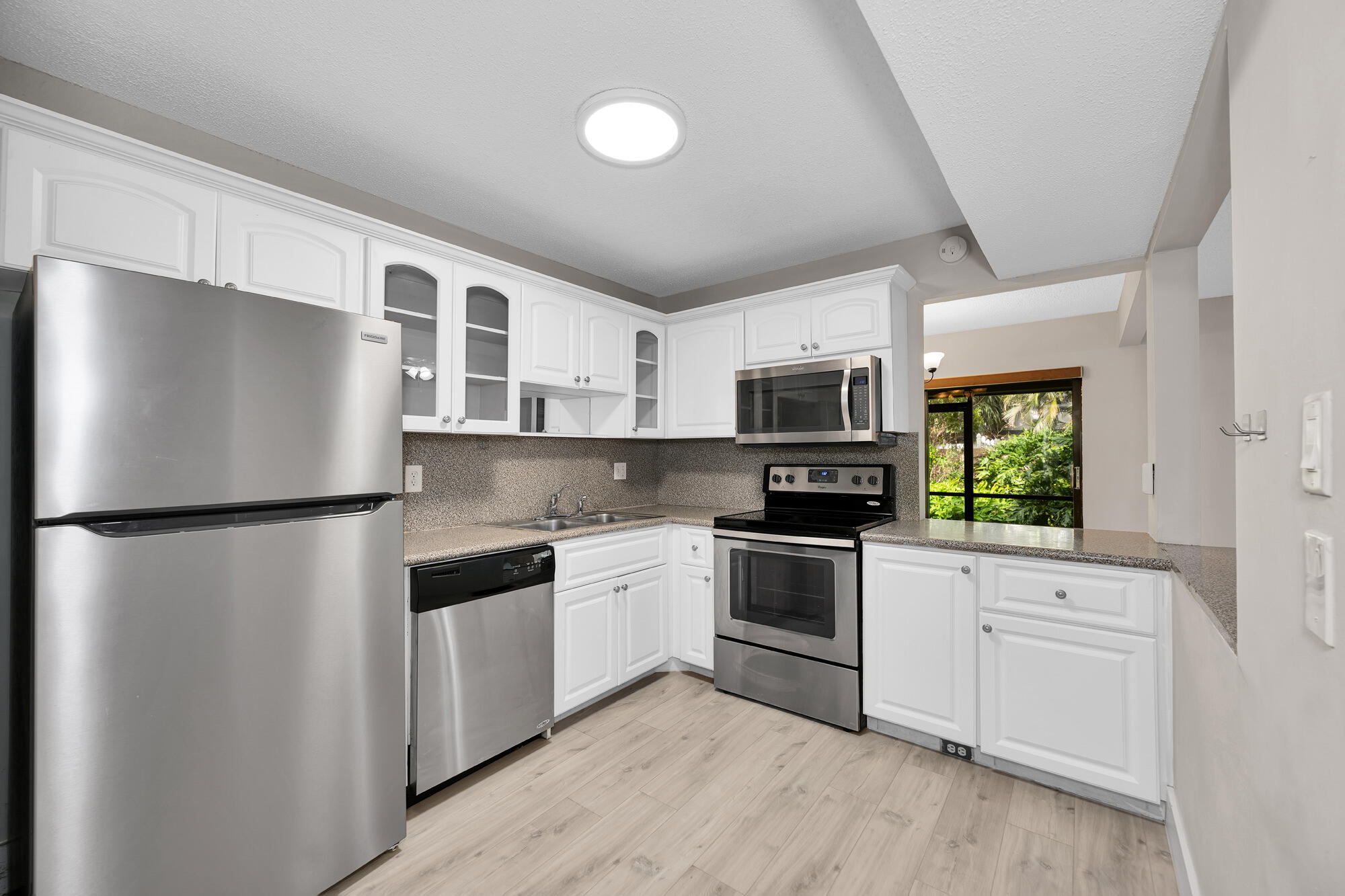1169 Northwest 13th Street, Unit 1 Boca Raton, FL 33486 - Photo 4 of 20 a kitchen with stainless steel appliances a refrigerator sink and stove