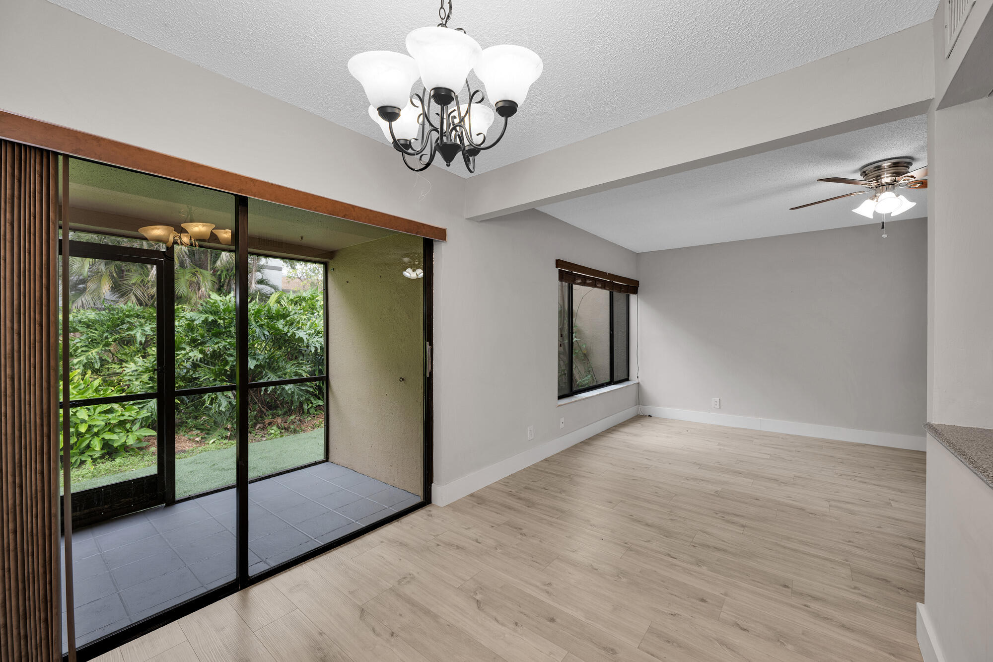 1169 Northwest 13th Street, Unit 1 Boca Raton, FL 33486 - Photo 5 of 20 a view of an empty room with a window and wooden floor