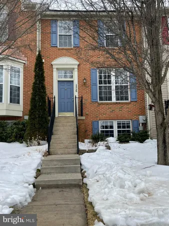 a front view of a house with a yard covered with trees