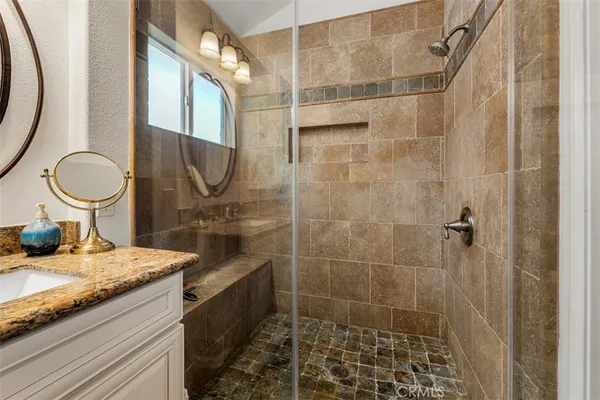 a bathroom with a granite countertop sink and a mirror