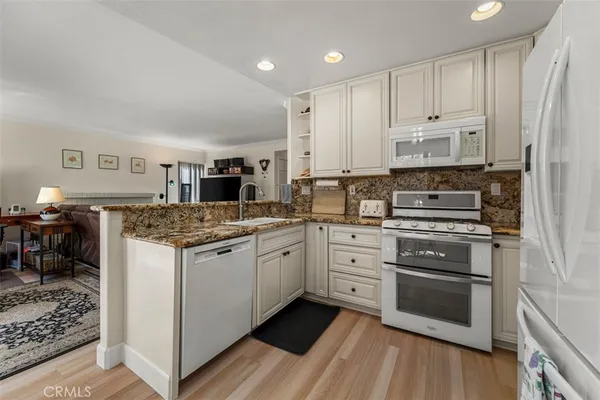 a kitchen with stainless steel appliances granite countertop a stove refrigerator and cabinets