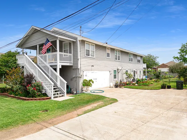 a front view of a house with a yard and potted plants