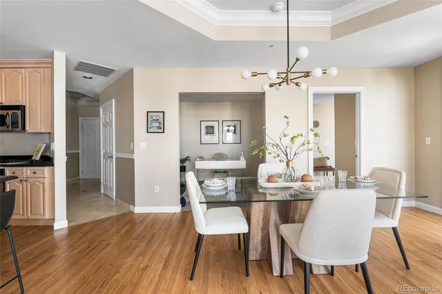 a view of a dining room with furniture a chandelier and wooden floor