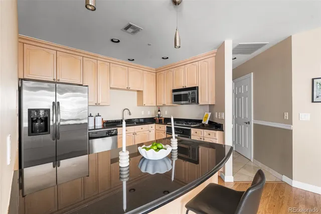 a kitchen with stainless steel appliances granite countertop a refrigerator a stove microwave and sink