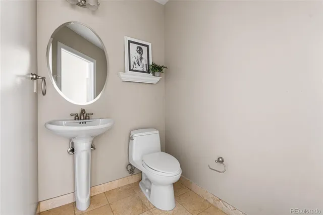 a bathroom with a toilet a sink and a mirror