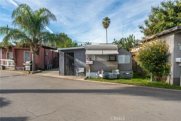 a view of a house with small yard and palm trees