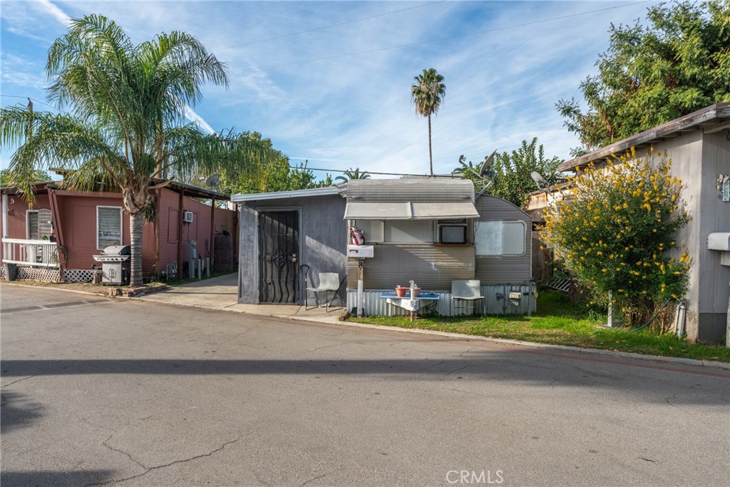 775 East Foothill Boulevard, Unit 14 Rialto, CA 92376 - Photo 5 of 18 a view of a house with small yard and palm trees