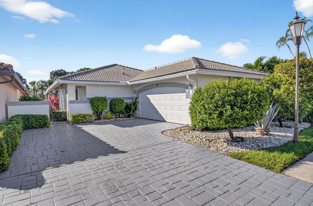 a front view of a house with a yard and potted plants