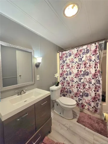 a bathroom with a sink toilet mirror and shower