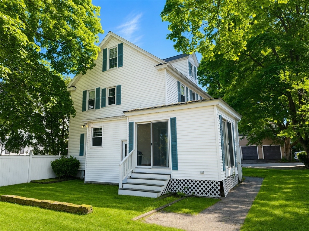 36 Plummer Avenue Lowell, MA 01852 - Photo 3 of 23 a view of a white house next to a yard with big trees