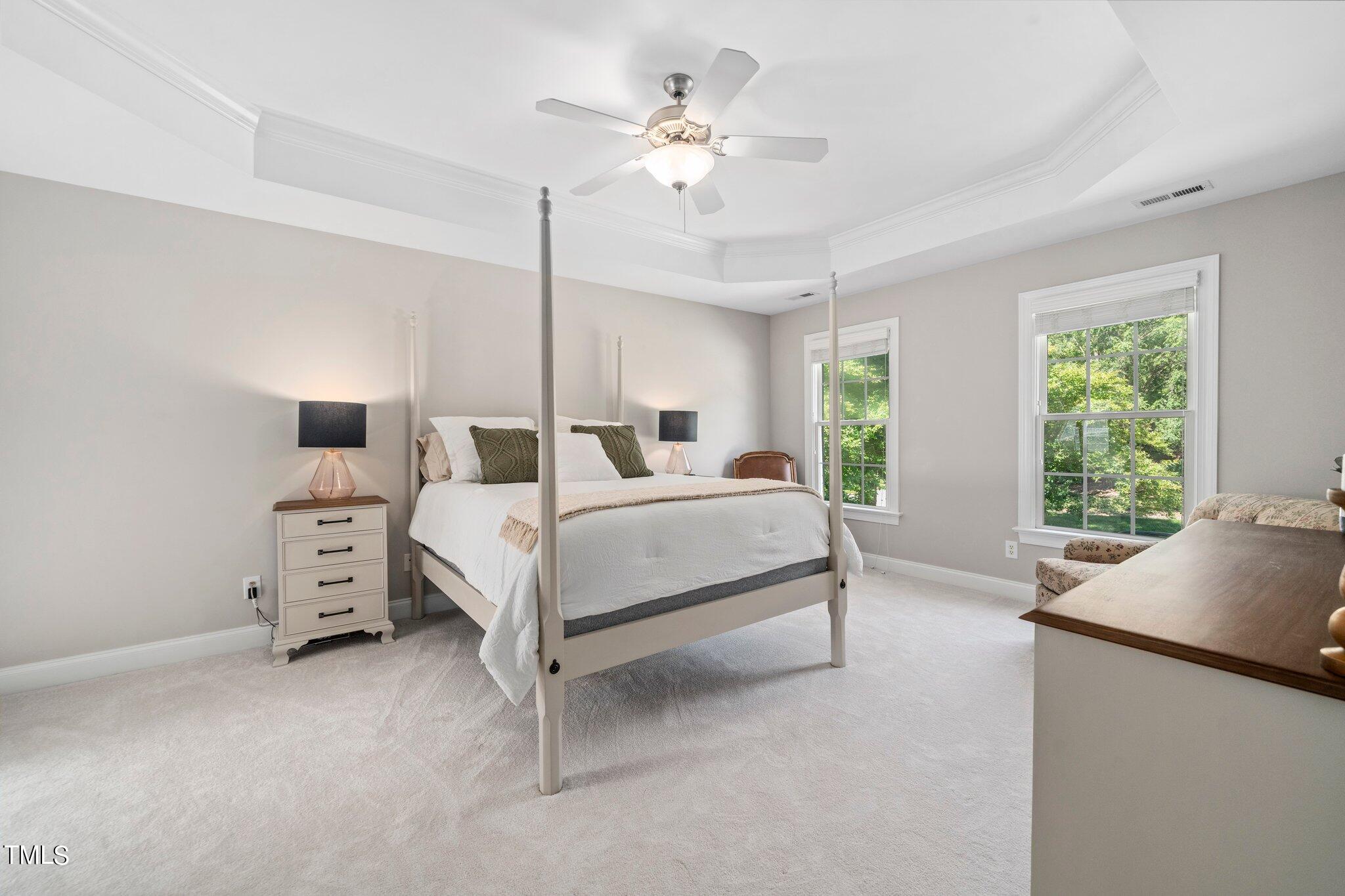 109 Chilcott Lane Apex, NC 27502 - Photo 19 of 34 a bedroom with a large bed and a chandelier