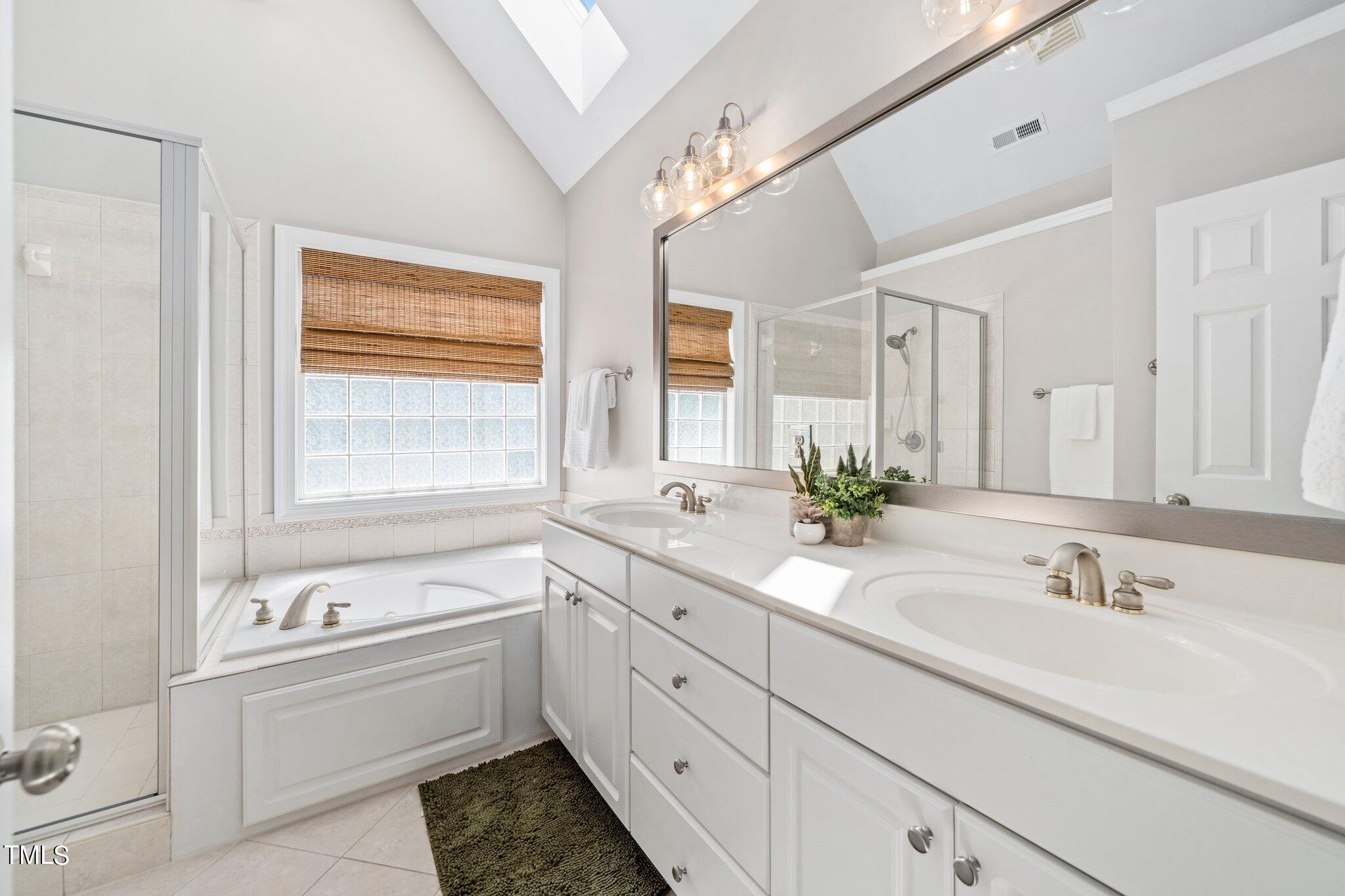109 Chilcott Lane Apex, NC 27502 - Photo 20 of 34 a bathroom with a tub sink double vanity granite and a vanity