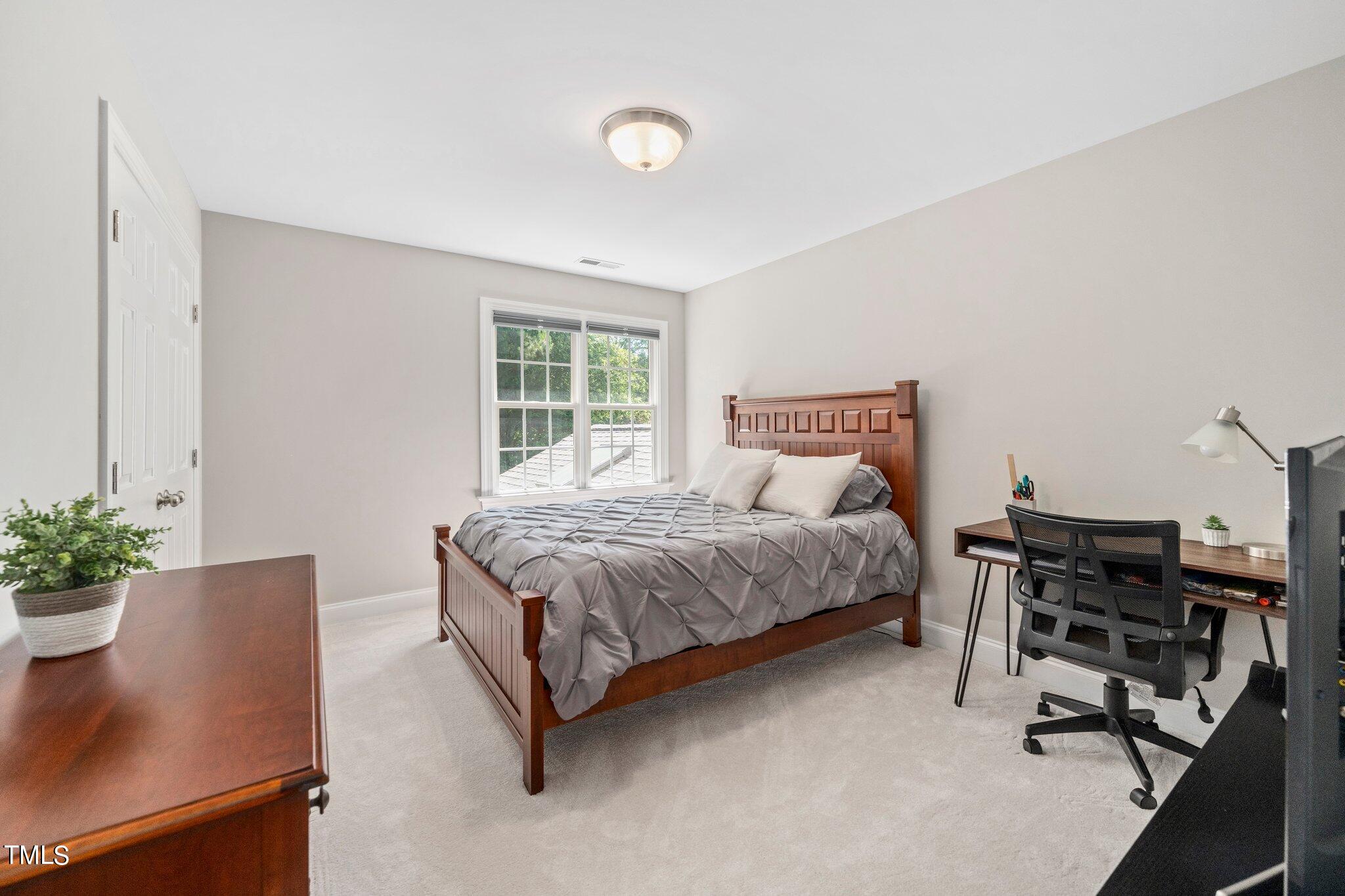 109 Chilcott Lane Apex, NC 27502 - Photo 23 of 34 a bedroom with a bed and a potted plant
