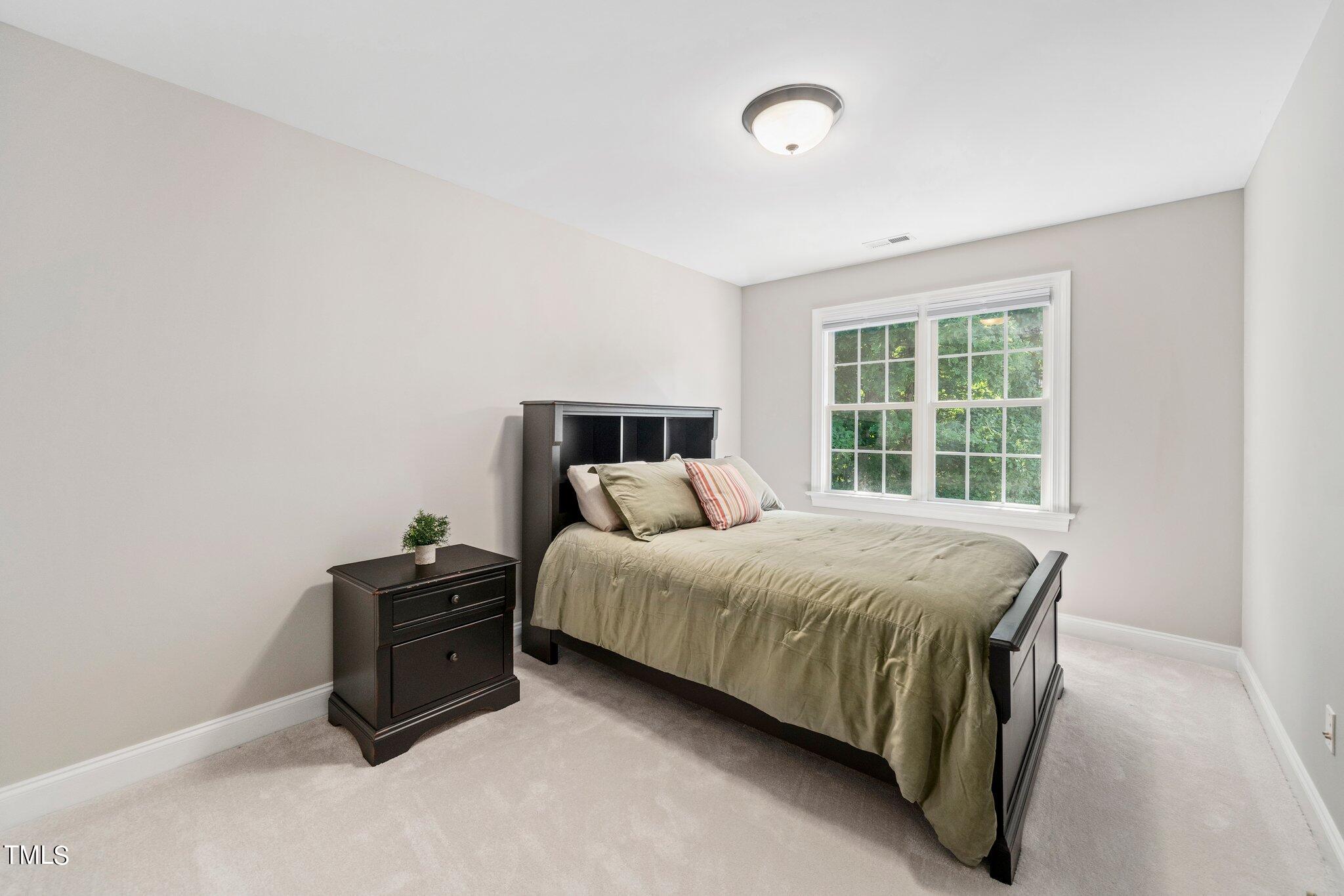 109 Chilcott Lane Apex, NC 27502 - Photo 24 of 34 a bed sitting in a room next to a window