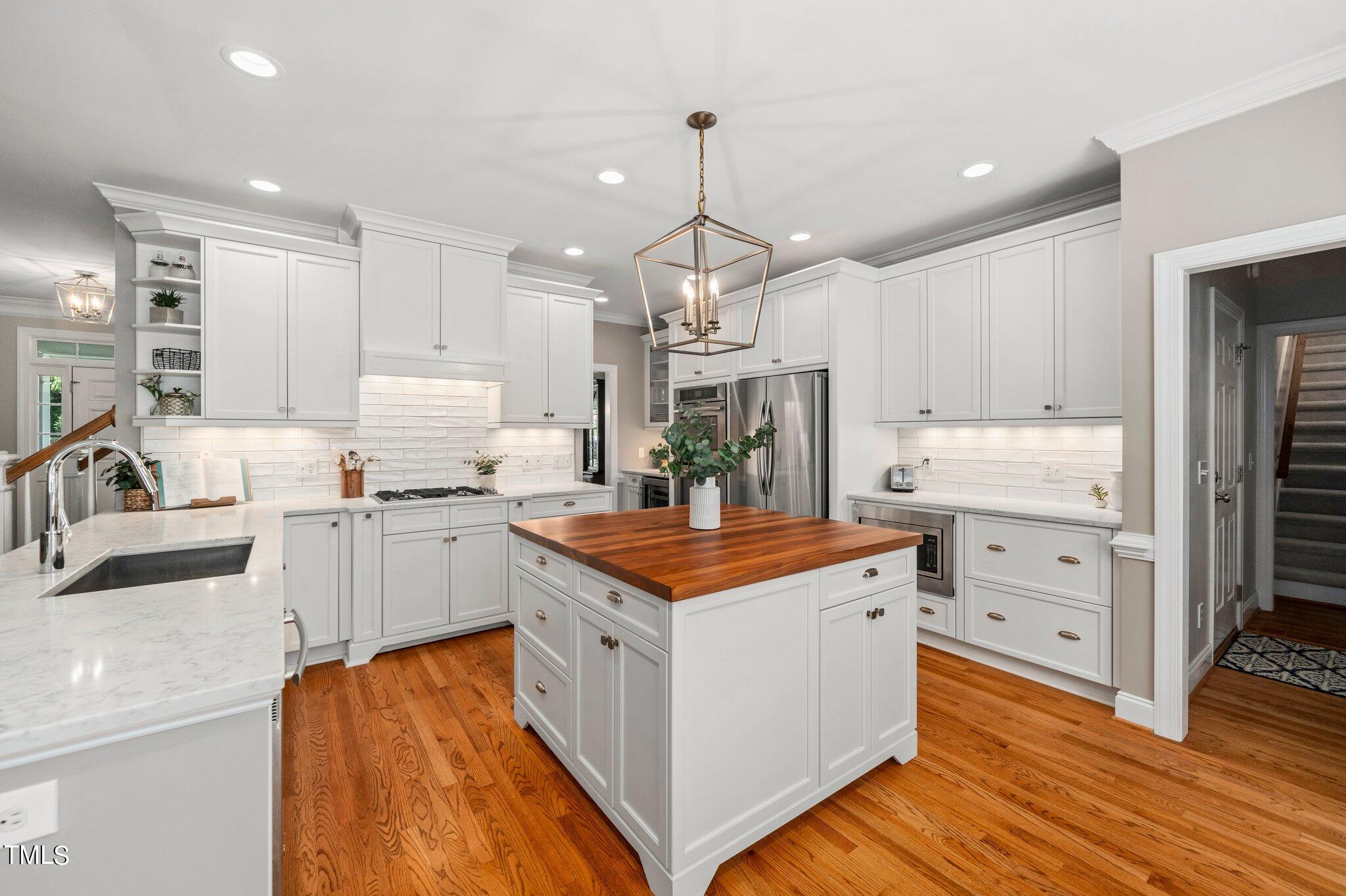 109 Chilcott Lane Apex, NC 27502 - Photo 5 of 34 a kitchen that has a lot of cabinets in it and wooden floors
