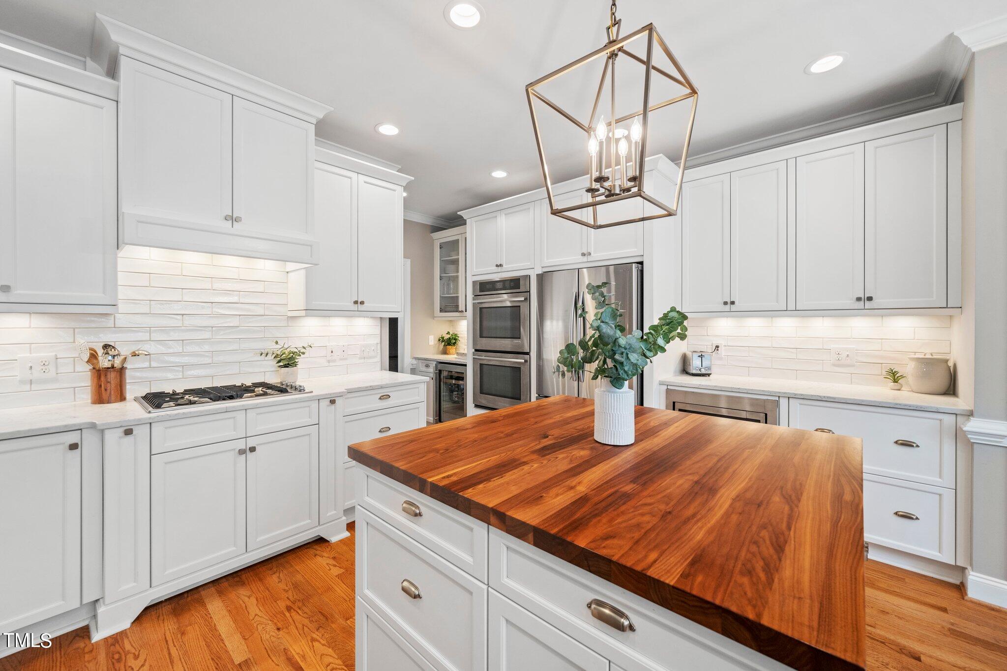 109 Chilcott Lane Apex, NC 27502 - Photo 7 of 34 a kitchen with kitchen island granite countertop a sink cabinets and wooden floor