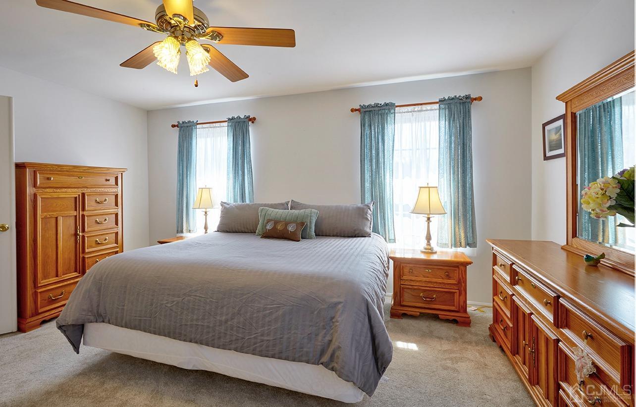 26 Glacier Drive Howell, NJ 07731 - Photo 15 of 31 a bedroom with a bed and a chandelier