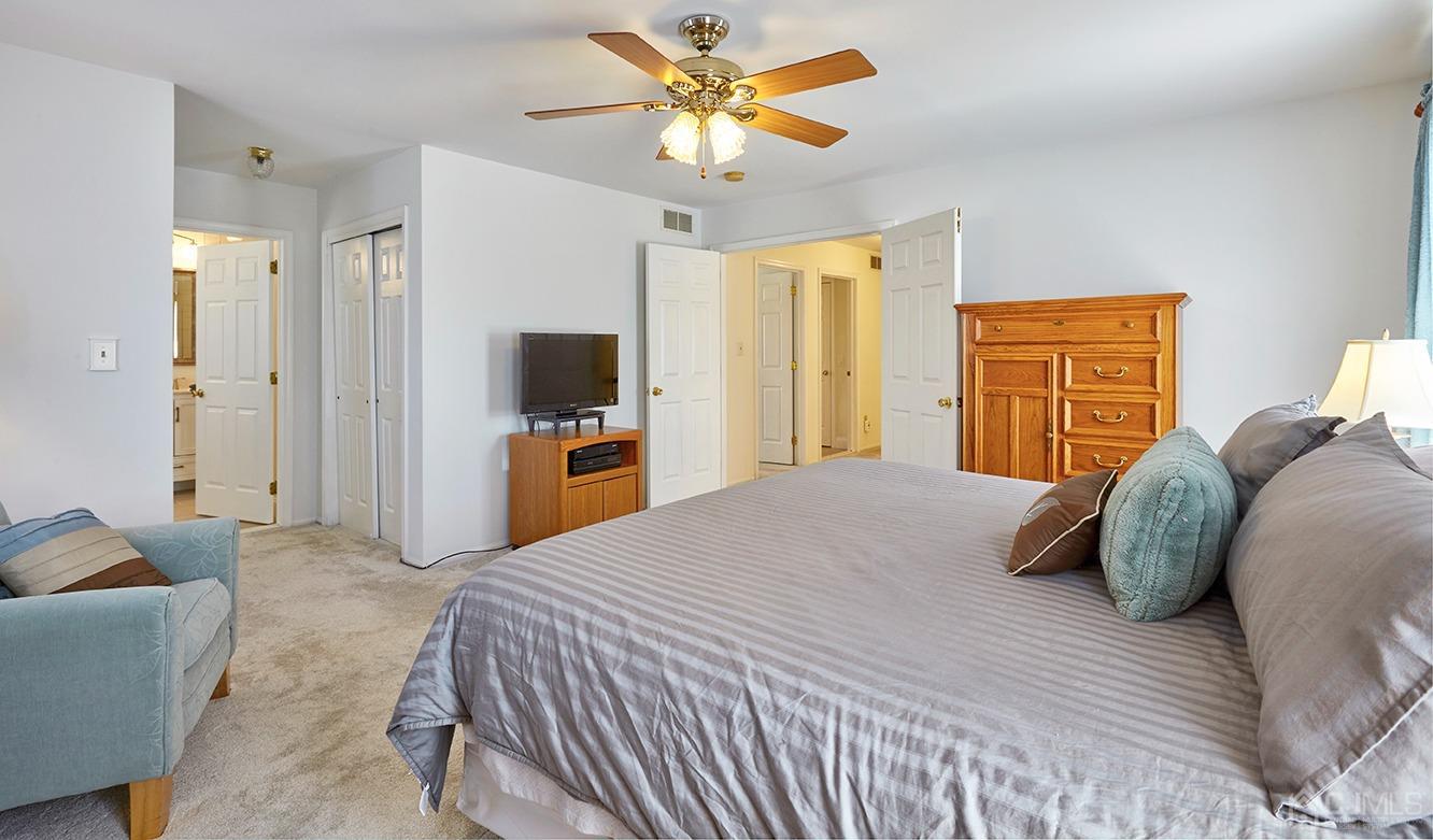 26 Glacier Drive Howell, NJ 07731 - Photo 16 of 31 a bedroom with a bed and a chandelier