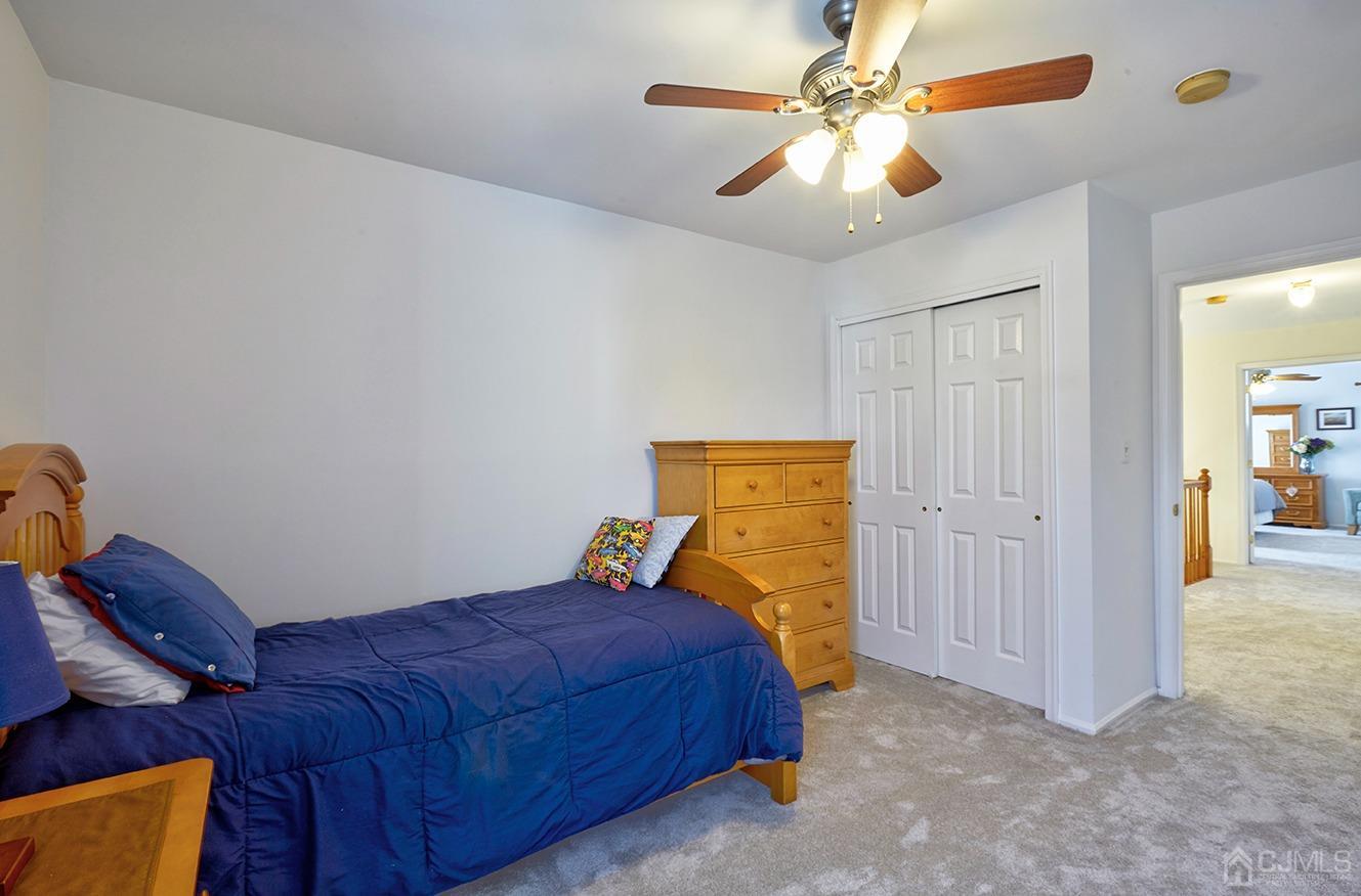 26 Glacier Drive Howell, NJ 07731 - Photo 21 of 31 a bedroom with a bed and a chandelier