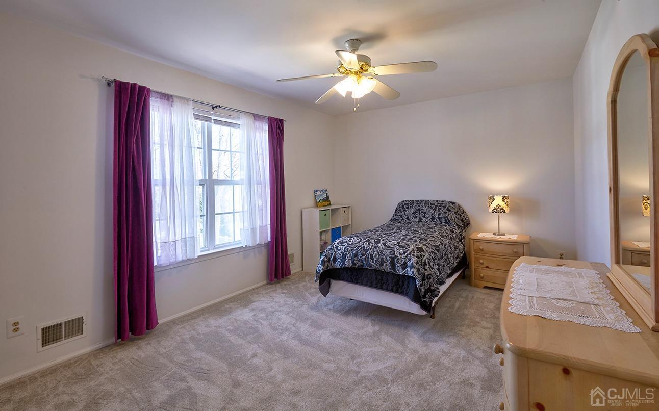 26 Glacier Drive Howell, NJ 07731 - Photo 22 of 31 a spacious bedroom with a bed and a chandelier