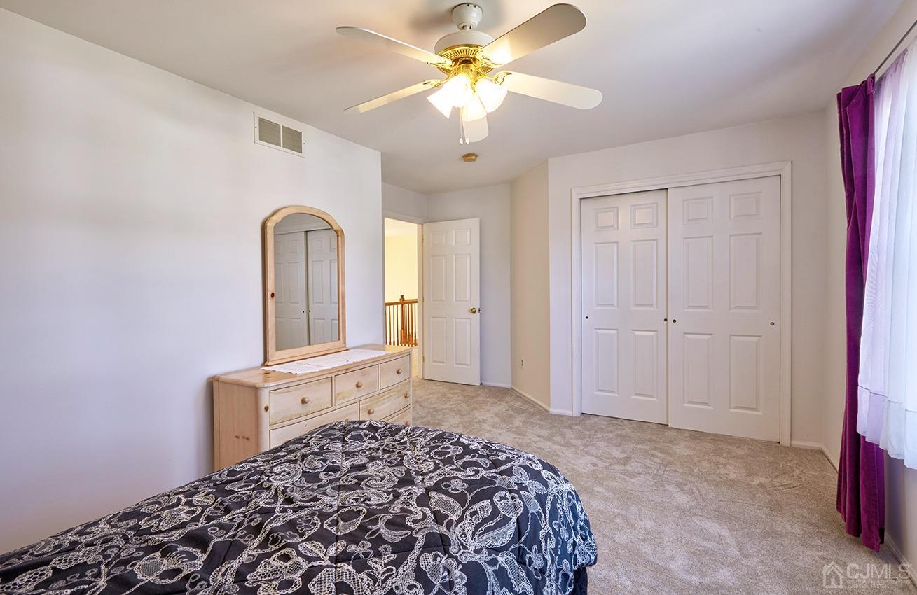 26 Glacier Drive Howell, NJ 07731 - Photo 24 of 31 a bedroom with a bed and a chandelier