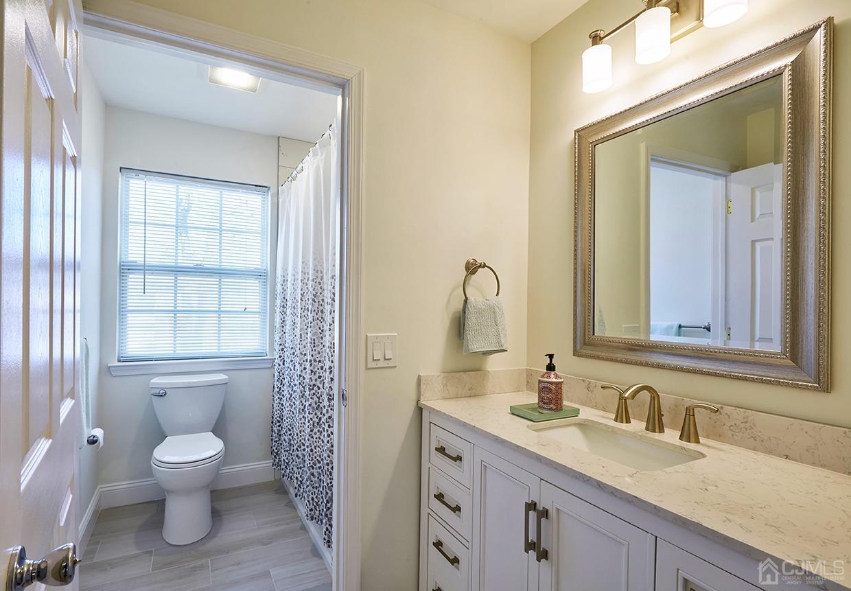 26 Glacier Drive Howell, NJ 07731 - Photo 28 of 31 a bathroom with a granite countertop toilet a sink and a mirror