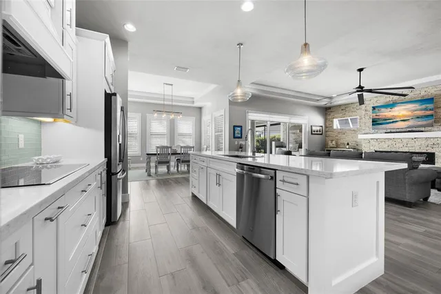 a kitchen with stainless steel appliances lots of counter top space and wooden floor