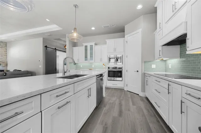a large kitchen with granite countertop lots of counter space sink and cabinets