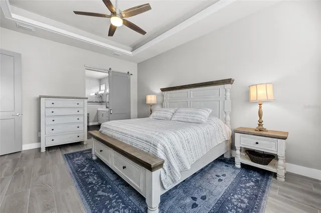 a spacious bedroom with a bed and a lamp